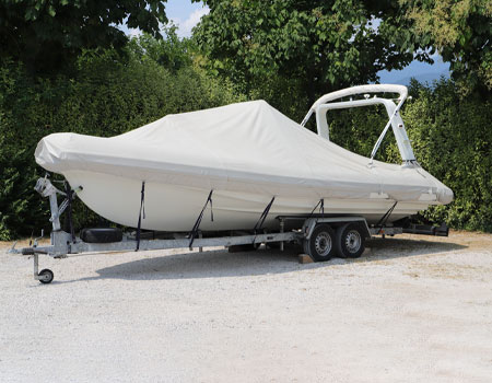 Boat being prepared for transport with protective wrapping and equipment, ensuring safe and secure delivery