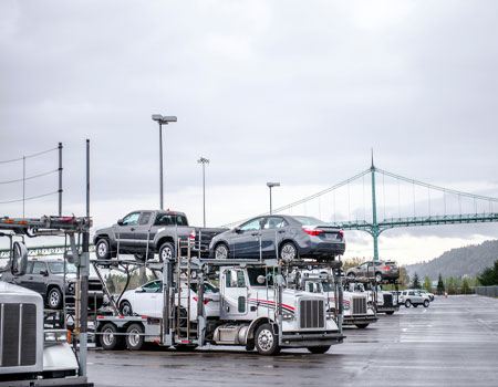 White semi-truck car haulers parked at a truck stop, representing carrier availability for expedited car transport services