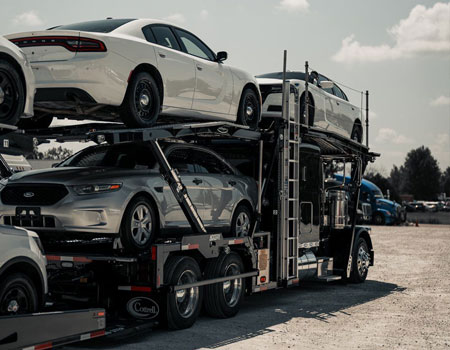 Classic open car carrier fully loaded with vehicles, offering reliable nationwide auto transport services
