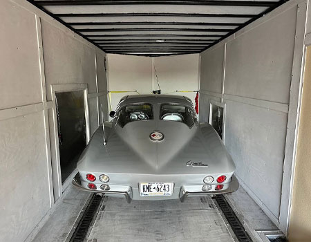 Classic vehicle positioned inside an enclosed trailer, ensuring safe and protected transport with enclosed auto shipping services