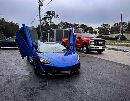 McLaren delivered with an enclosed trailer to a residential location, showcasing door-to-door luxury auto transport services