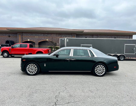 Rolls-Royce delivered to a residential location with an enclosed car carrier in the background, showcasing luxury enclosed auto transport services
